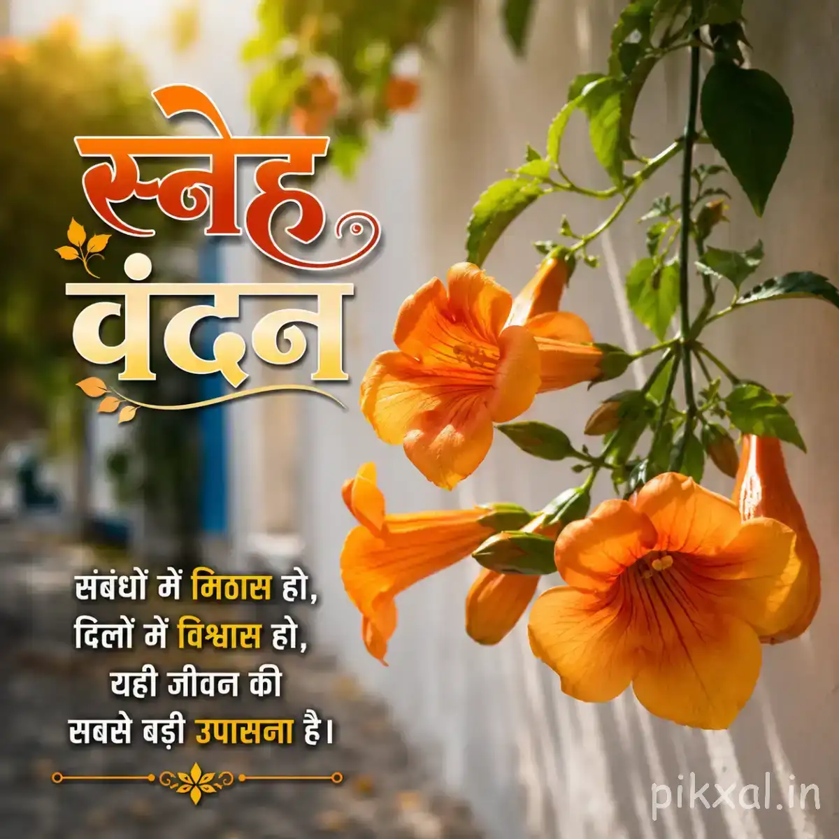Orange trumpet-shaped flowers hanging from leafy green branches against a softly blurred garden background with a Hindi morning greeting