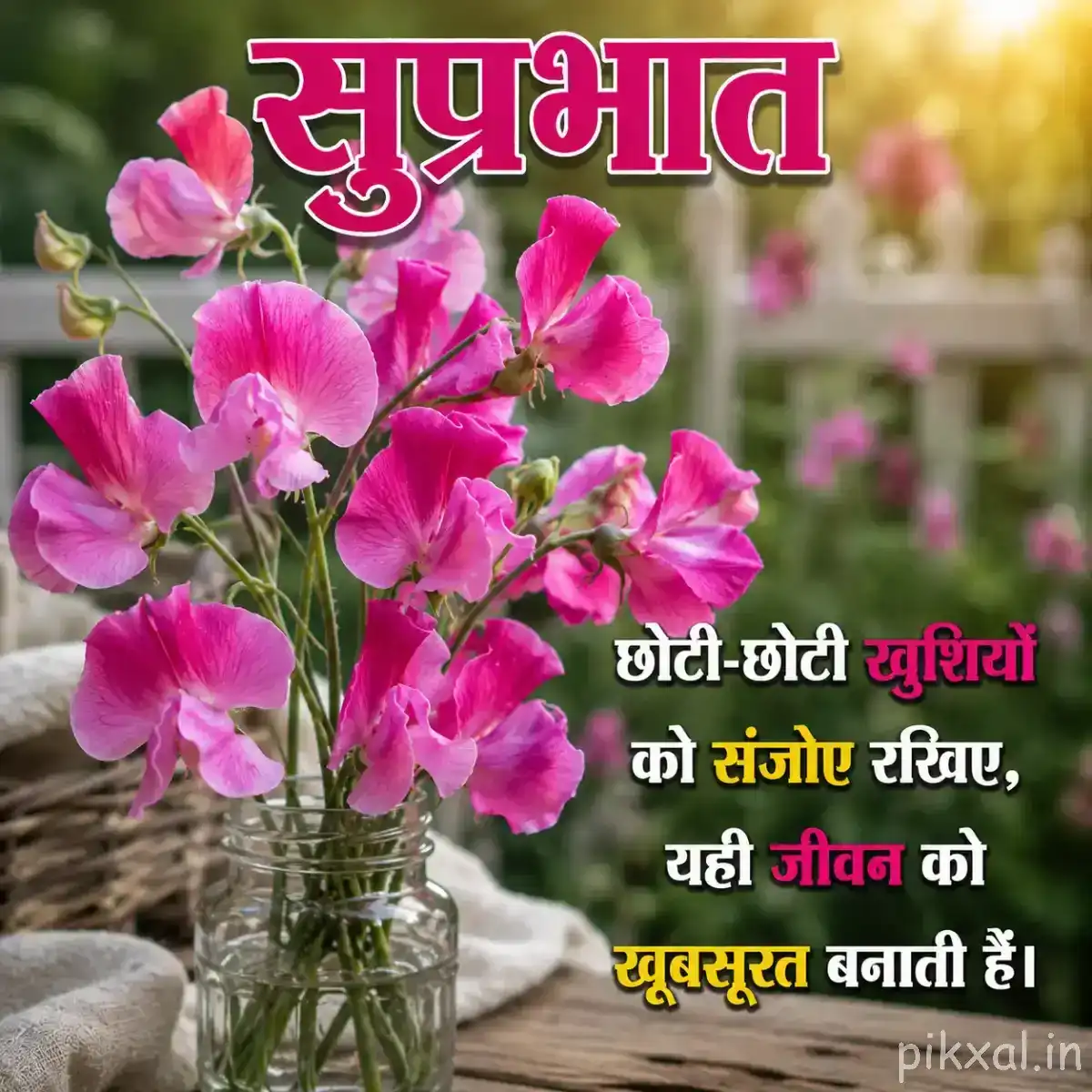 Several light pink flowers and buds arranged in a glass vase with a Hindi Good Morning wish