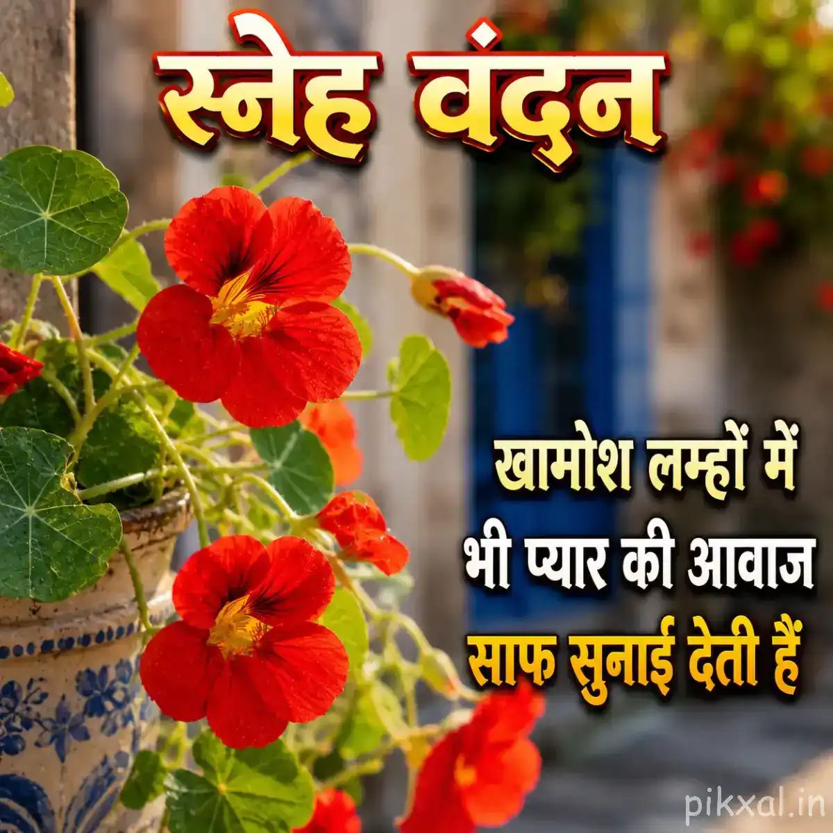 Red flowers with green leaves beside a building and a Hindi morning wish